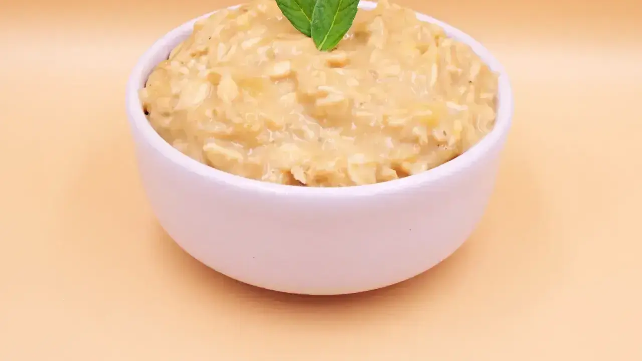 Pyszna owsianka z bananem, kremowa i sycąca, udekorowana listkami mięty. Idealna na zdrowe śniadanie.