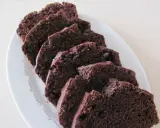 Pokrojona babka z kakao, ułożona na białym talerzu, kusi wilgotnym, ciemnym wnętrzem.