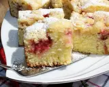 Błyskawiczne i super łatwe ciasto z owocami, posypane cukrem pudrem, na białym talerzu.