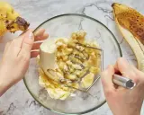 Ręce ugniatają banany w misce, przygotowując pyszny deser z bananów. Obok leżą dojrzałe banany.