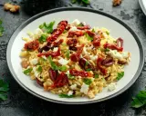 Pyszna sałatka z makaronem orzo, z suszonymi pomidorami, fetą, oliwkami i natką pietruszki.