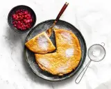 Puszysty omlet z air fryera, posypany cukrem pudrem, podany z żurawiną. Idealny na śniadanie.