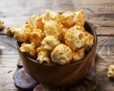 Pyszny karmelowy popcorn w drewnianej misce. Idealny do domowego seansu, gdy wiesz, jak zrobić popcorn w garnku.