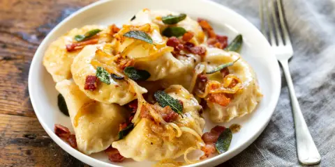 Pyszne pierogi z boczkiem i cebulką. Dowiedz się, ile gotować pierogi, by były idealne.