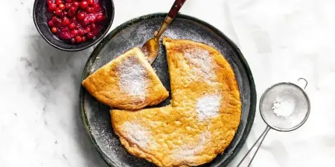 Puszysty omlet z air fryera, posypany cukrem pudrem, podany z żurawiną. Idealny na śniadanie.