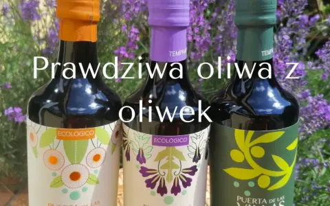 Trzy butelki oliwy z oliwek "Puerta de las Villas" na tle lawendy. To prawdziwa oliwa z oliwek, idealna do każdej potrawy.