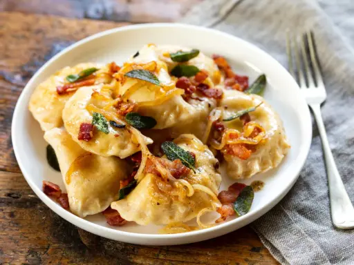 Pyszne pierogi z boczkiem i cebulką. Dowiedz się, ile gotować pierogi, by były idealne.