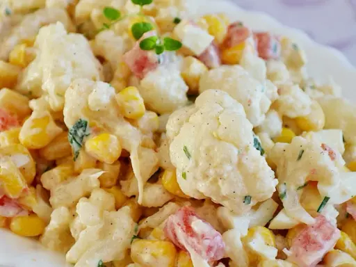 Pyszna sałatka z kalafiora z kukurydzą i papryką, polana kremowym sosem. Idealna na letnie dni.