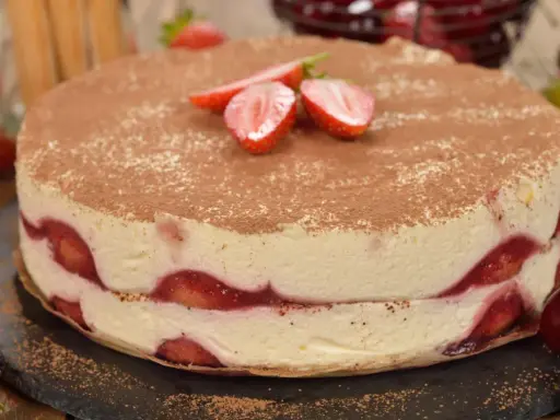 Pyszne ciasto z truskawkami, przełożone kremem i posypane kakao. Idealne na letnie popołudnie.