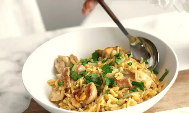 Szybki obiad z makaronem orzo i kurczakiem, posypany natką pietruszki. Idealny na szybki posiłek.