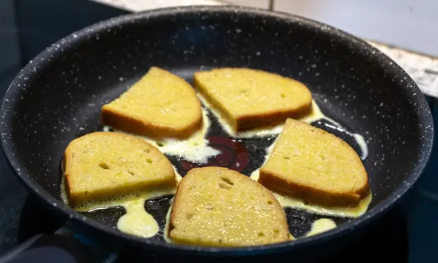 Pięć kromek chleba w jajku smaży się na patelni, tworząc pyszne śniadanie.