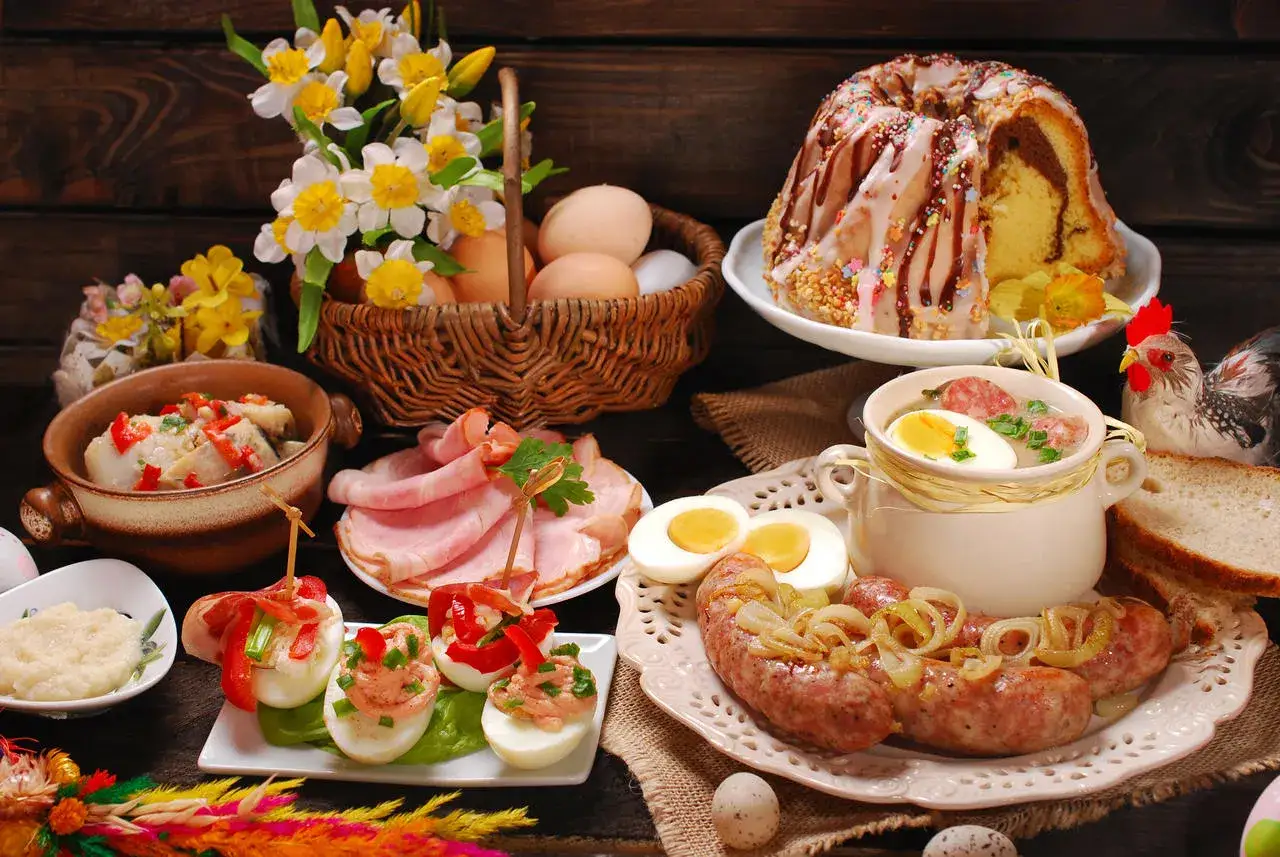 Wielkanocne potrawy: babka, kiełbasa, jajka faszerowane, śledź, chrzan i żurek. Lista przysmak&oacute;w na świątecznym stole.