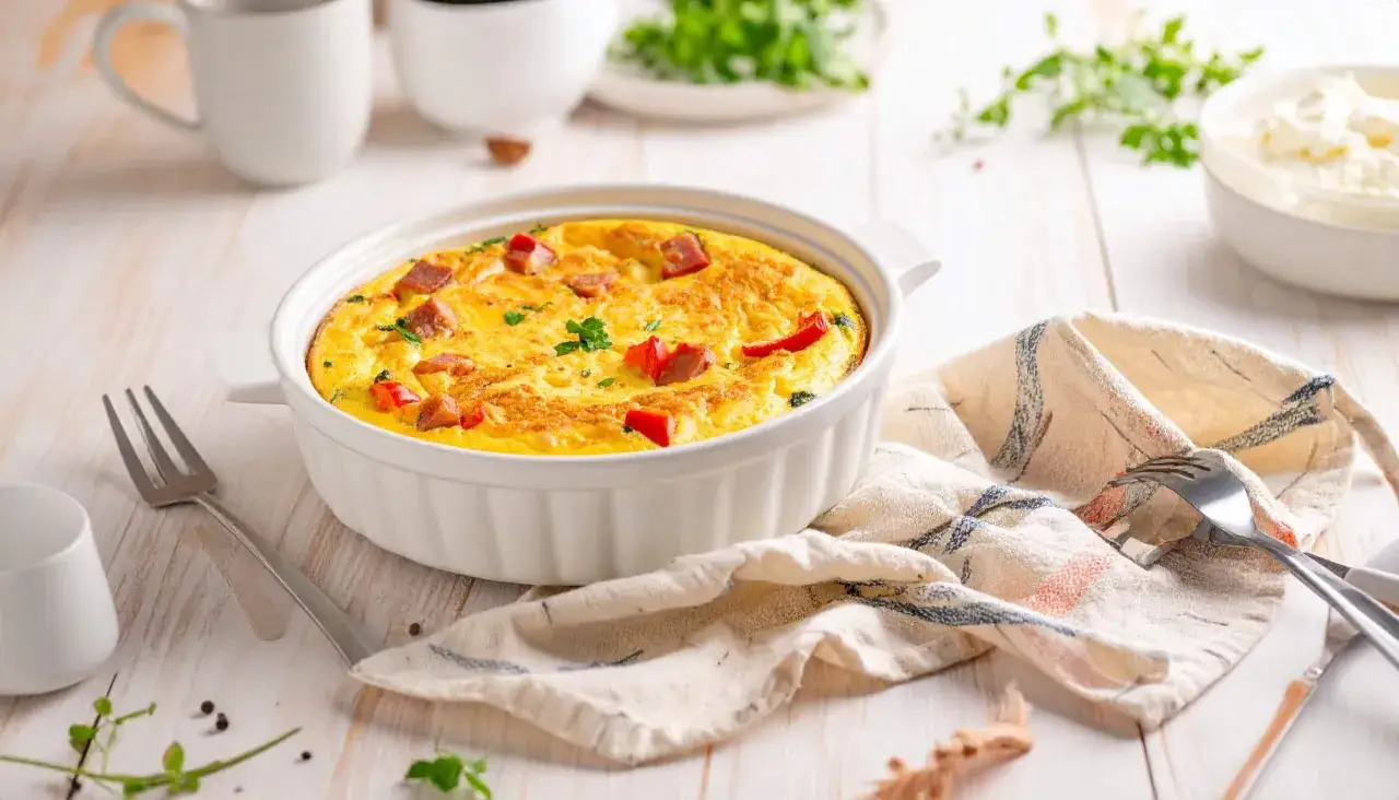 Pyszny omlet z warzywami i kiełbasą, przygotowany w air fryerze, podany w białej formie. Idealny na śniadanie.