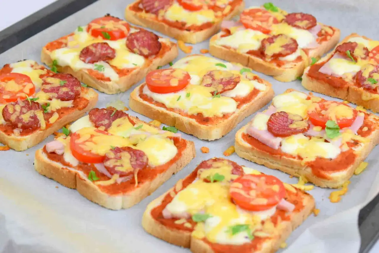 Pyszne, domowe pizza z chleba tostowego z serem, salami i pomidorkami. Idealna przekąska dla całej rodziny.