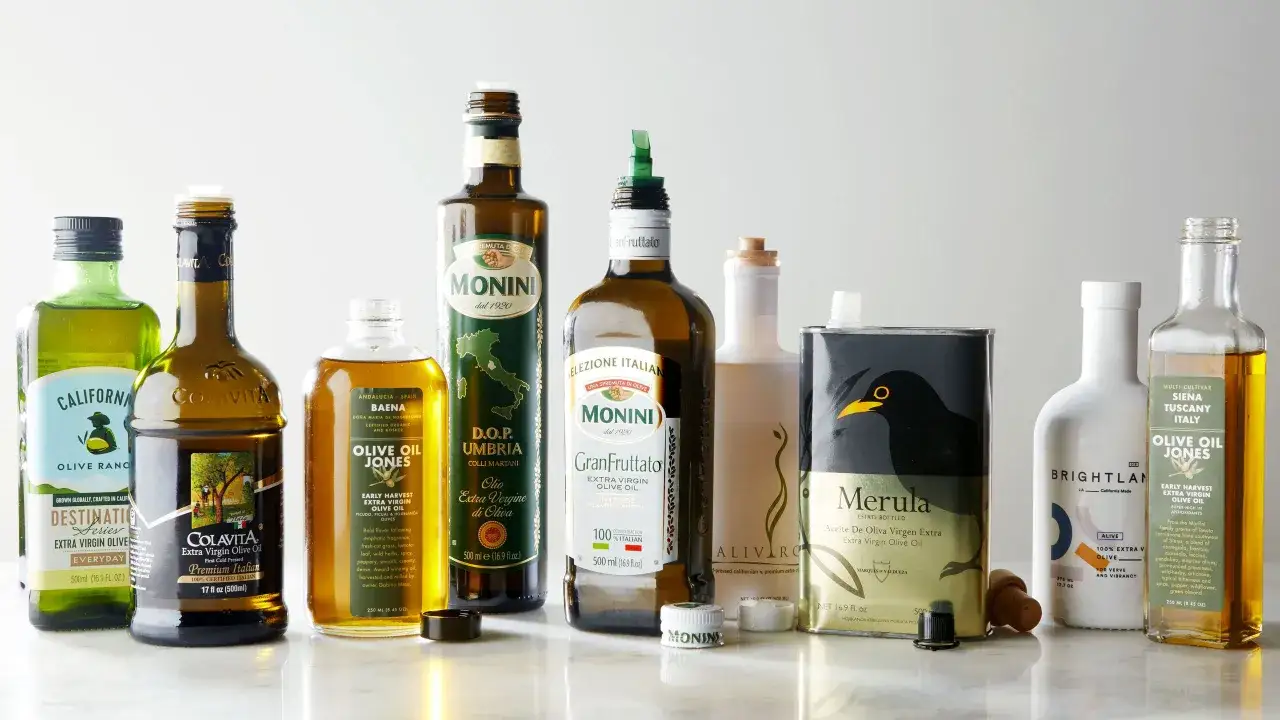 Wyb&oacute;r butelek i puszek z oliwą z oliwek, w tym Colavita, Monini i Olive Oil Jones. To dobra oliwa z oliwek na każdą okazję.