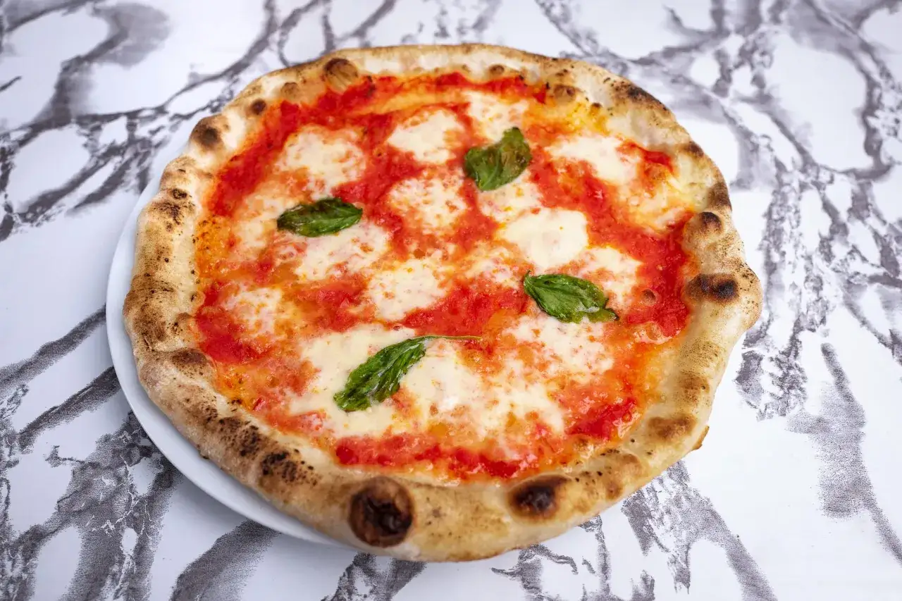 Idealna pizza neapolitańska przepis: klasyczna Margherita z pomidorami, mozzarellą i bazylią, na chrupiącym cieście.