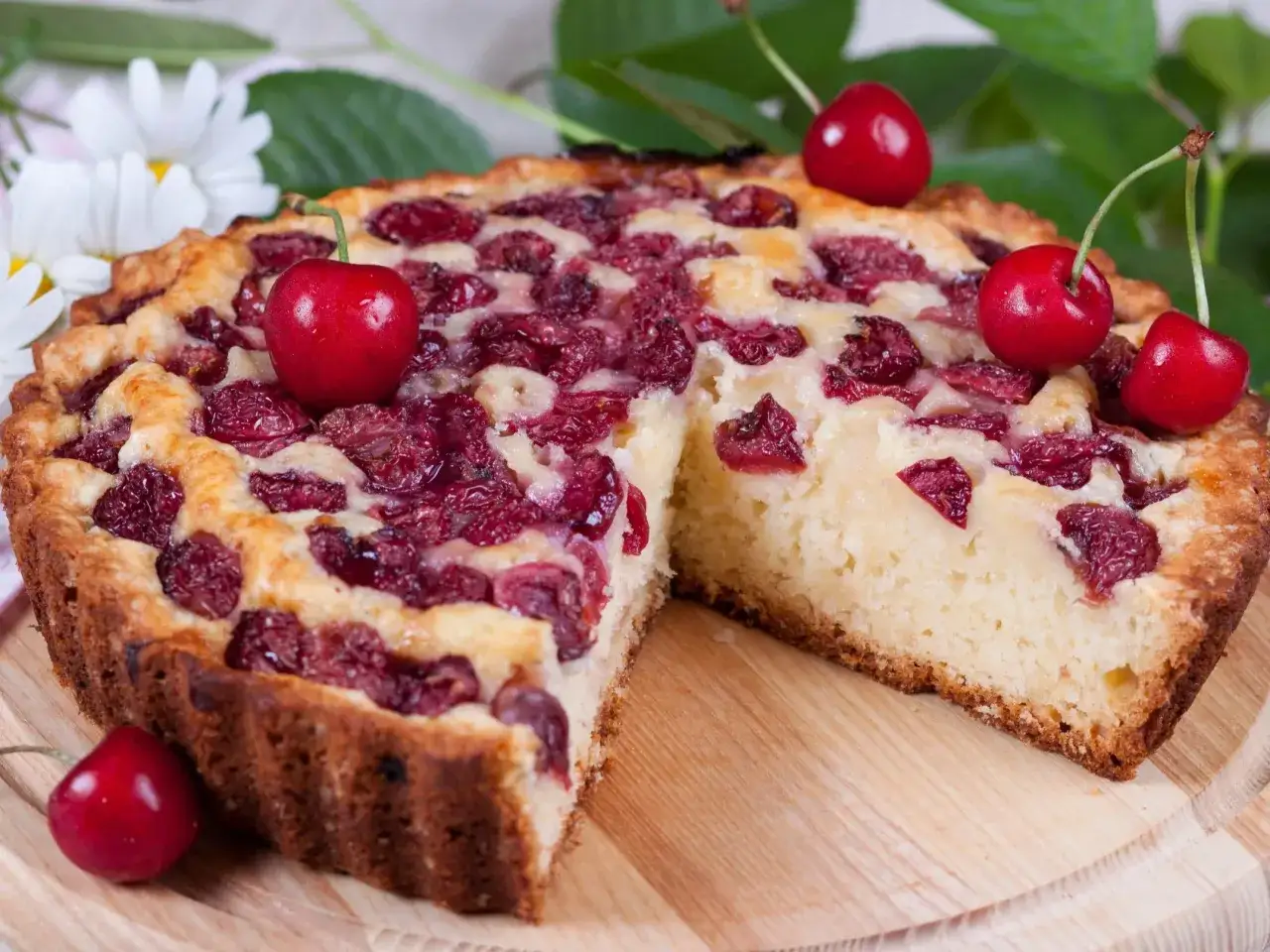 Pyszne ciasto z czereśniami, z rumianą sk&oacute;rką i soczystymi owocami, ozdobione świeżymi czereśniami.